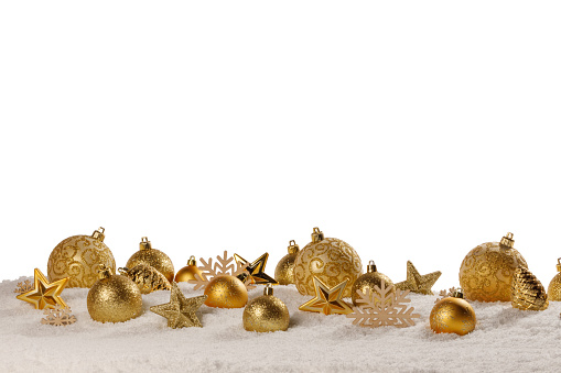 Christmas golden decoration of baubles and stars in a row on snow isolated on white background