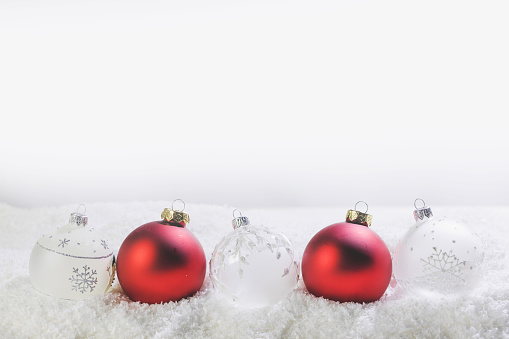 Red and white Christmas balls on white snow background with copy space