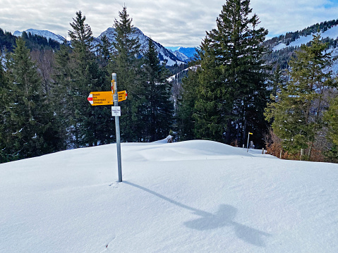 Hiking markings and orientation signs with signposts for navigating in the idyllic winter ambience of the Alpstein massif in the Swiss Alps - Schwägalp mountain pass, Switzerland (Schweiz)