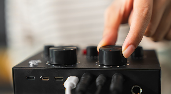 Close up of hand press control panel, audio engineer, music creator.