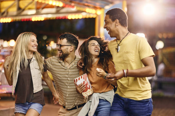 istock Cheerful couples having fun at amusement park. 1438065898