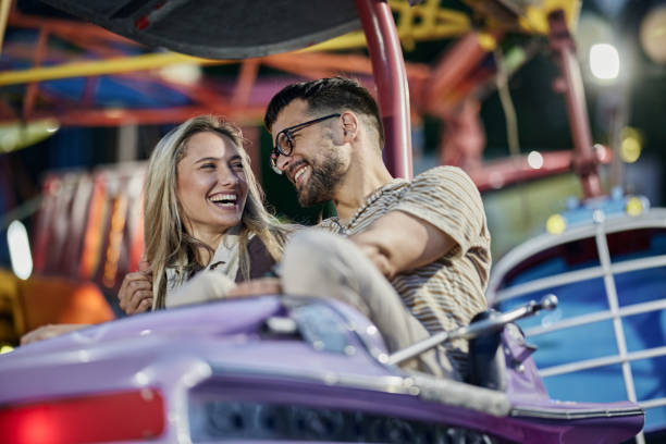 istock Young cheerful couple having fun during a ride at amusement park. 1438065950
