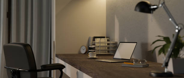 istock Modern minimal home workspace with laptop ,glasses, table lamp and decor on wood tabletop 1438065969