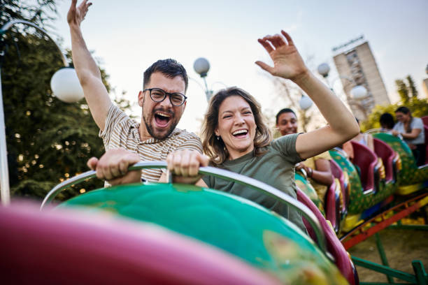 istock Young happy couple having fun on rollercoaster at amusement park. 1438065995