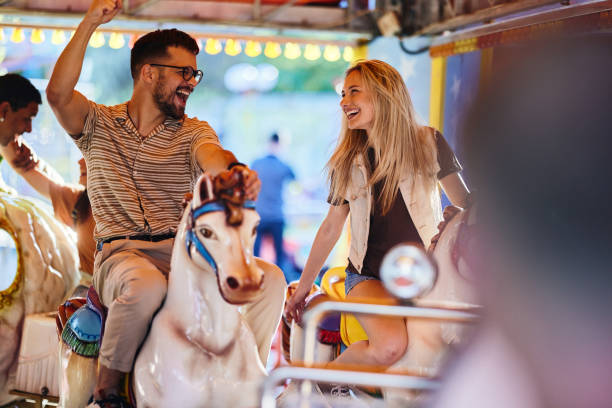 istock Carefree couple having fun during a ride at amusement park. 1438066083