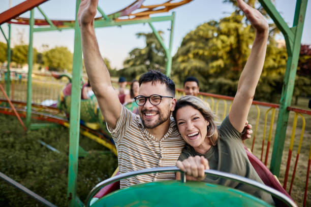 istock Young carefree couple having fun on rollercoaster ride at amusement park. 1438066138