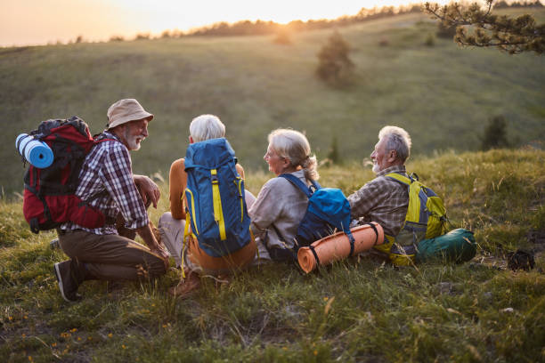 istock Happy mature friends talking on a break from hiking at sunset. 1438066953