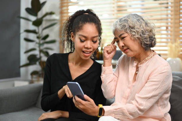 istock Caring grownup daughter teaching older mother using social networks on smart phone. Elderly, technology concept. 1438067673
