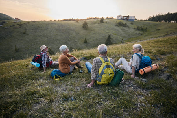 istock Group of seniors talking while resting on a hill from hiking in springtime. 1438067790
