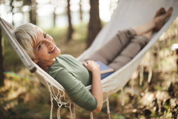 istock Happy senior woman enjoying in hammock. 1438067815