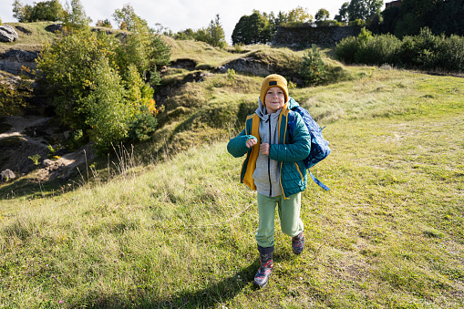 Child with missing teeth smiles while taking a hike in nature