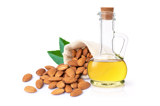 Almond oil and almond nuts isolated on white background.