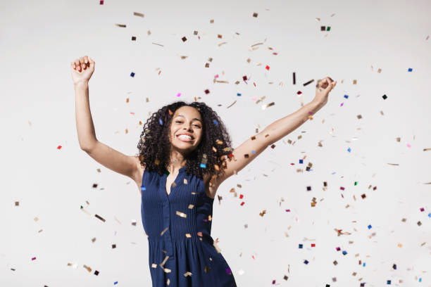 istock Joyful woman laughing, dancing and has fun with falling confetti. Enjoying life, celebration concepts 1438075244