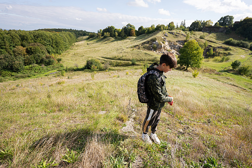 Activity on sunny autumn day, boy exploring nature. Kid wear backpack hiking.