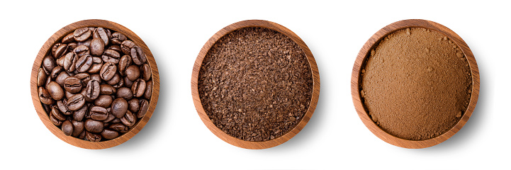 Roasted coffee beans and coffee powder (ground coffe) in wooden bowl isolated on white background. Top view. Flat lay.