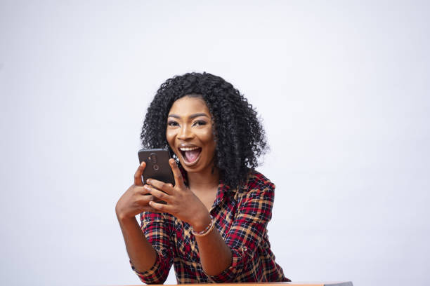 istock Happy young African lady using her phone. 1438076433