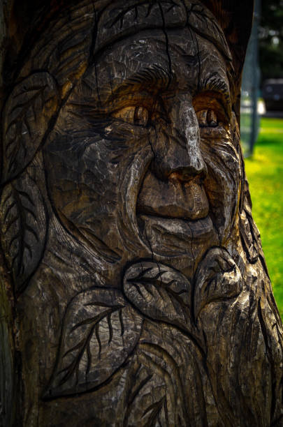 A closeup of a tree stump carved with an old man’s face