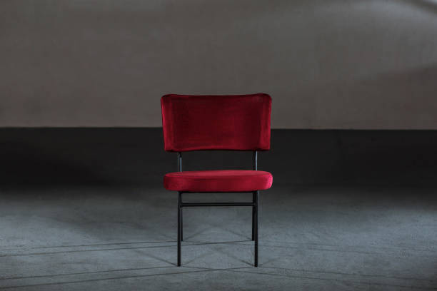 istock Comfy red wing chair in a studio with gray walls 1438078691