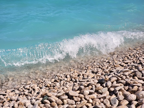 A beautiful shot of blue sea waves splashing against a rocky shore