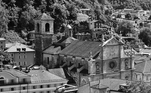 Bellinzona, Switzerland – August 09, 2022: A grayscale aerial view of a cathedral and nearby buildings in Bellinzona, Switzerland