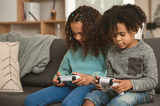 Young kids at home playing video games together