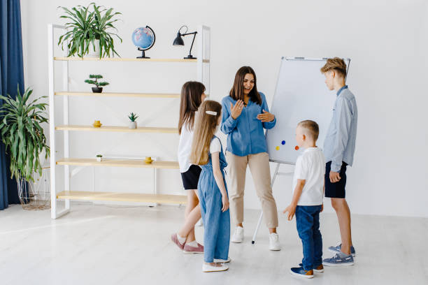istock Explaining lesson and using board. Group of children students of different ages in class at school with teacher. Learning concept 1438078995