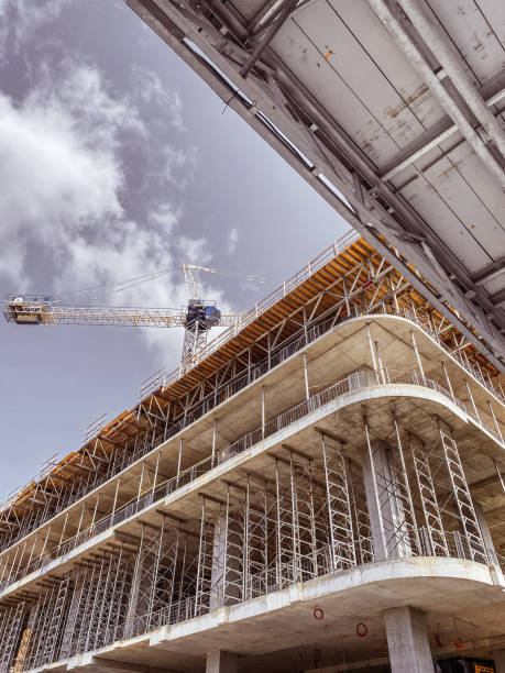 istock Low angle shot of a building under construction with thin clouds background 1438079278