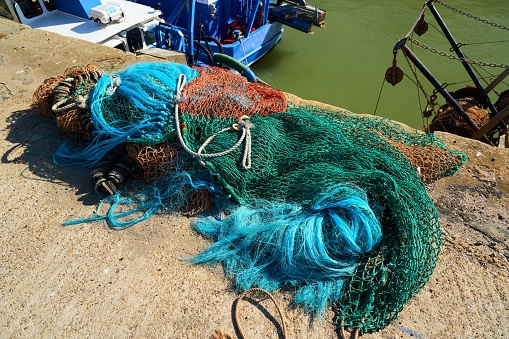 A bundle of fishing nets on the ground at harbor
