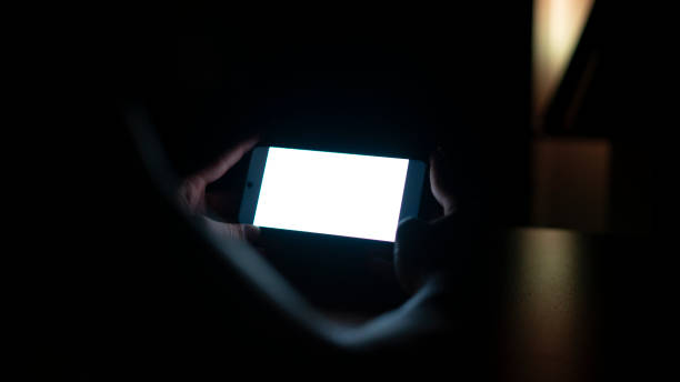 istock Man holding phone in the dark at night , Mock Up screen 1438079577