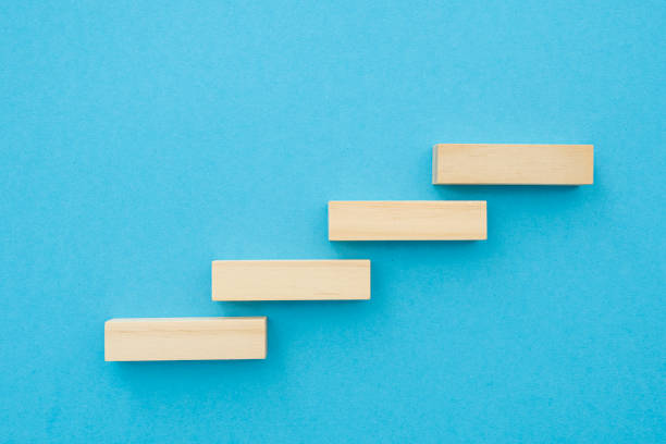istock Four wooden small planks, long shape with blank surface growing up on blue background, for business concept ideas 1438080746