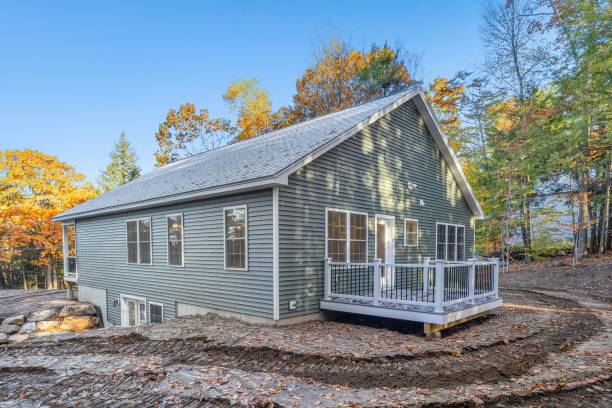 istock House with grey exterior and a backyard deck with a fence in a forest surrounded by autumn foliage 1438081987