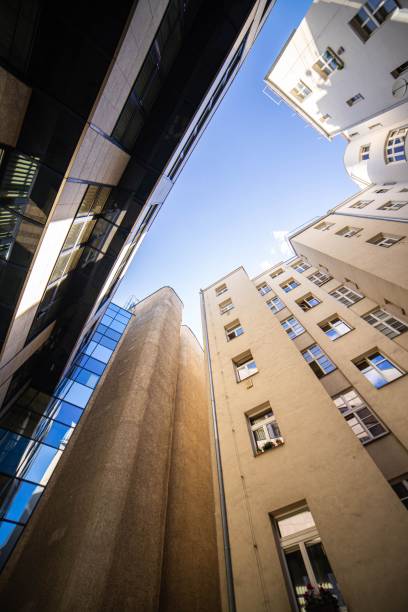 istock Vertical low-angle view of tall buildings with windows under a blue sky during the day 1438082450