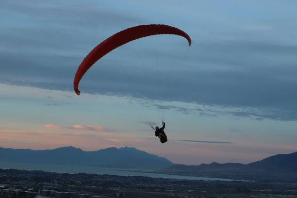 istock Person paragliding in between beautiful mountains 1438085116