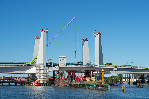 Gothenburg, Sweden – August 31, 2020: Construction of a new bridge between Gothenburg and Hisingen over Gota alv. The lifting range is towed forward to be mounted.