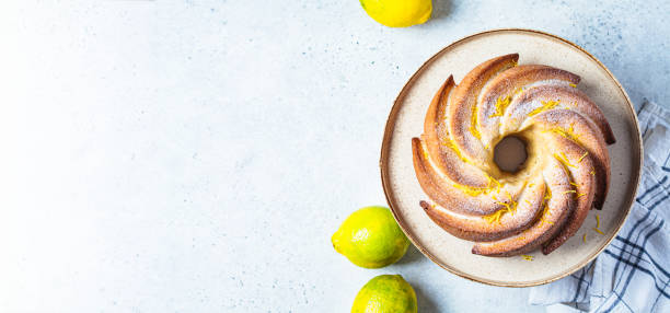 Traditional lemon cake on a cake stand, gray background, top view, copy space.