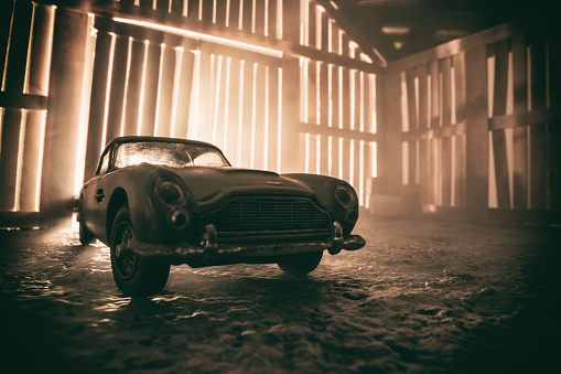 Beaconsfield, UK - October 28, 2022: An old and dusty Aston Martin DB5 sits neglected in an old wooden barn.