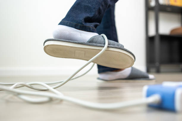 istock A man stumbles upon a cluttered wire lying on the ground. Stumbled until the head hit the ground. Accident at home It is because of carelessness and clumsiness electric shock 1438089590