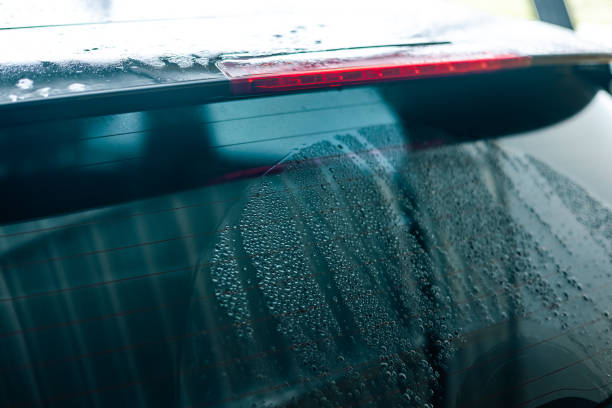 istock Water droplets on car windshield. Car wash cleaning 1438090150