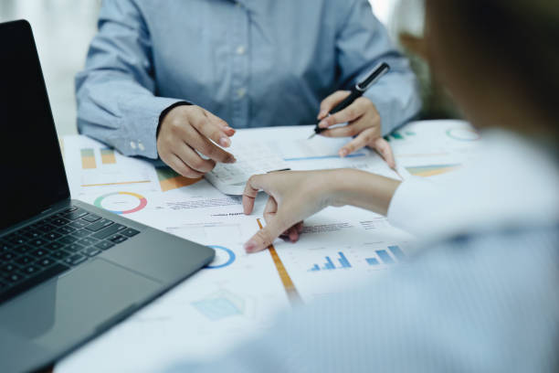 istock Financial analysts analyzing business reports on planned investment projects during corporate meeting discussions showcase successful teamwork with marketing plan, computers and calculators to work 1438090261