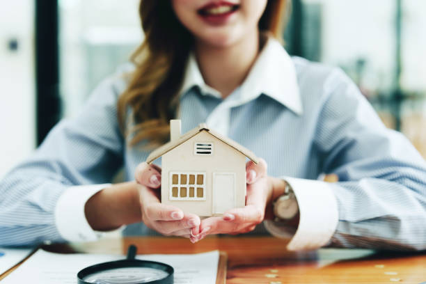 istock customer holding a magnifying glass to look at a house model inspection 1438091086