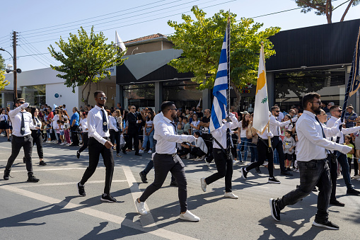 Limassol, Cyprus, October 28th, 2022: Male high school students in uniform with flags marching along the Archbishop Makarios III Avenue during Ohi Day parade