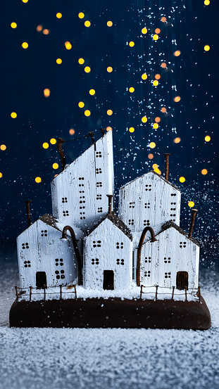 winter christmas composition night city in the snow, wooden houses from driftwood