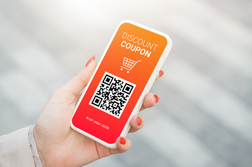 female hand holding a discount coupon with QR code on smartphone. mobile application