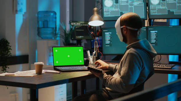 istock Impostor with mask hacking network with greenscreen on laptop 1438103471