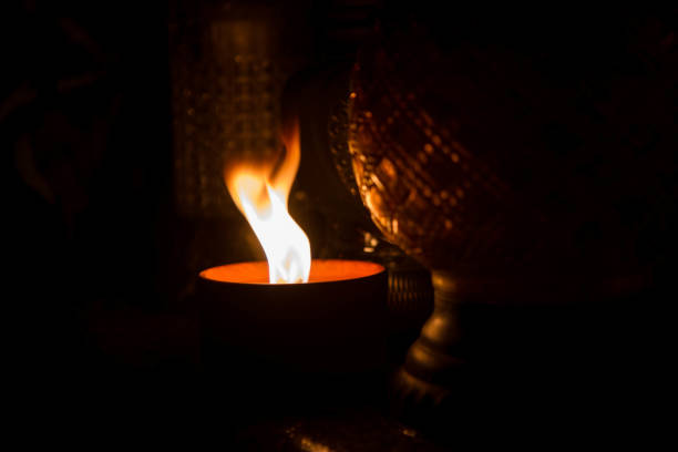 Votive candle burning at a cemetery at night