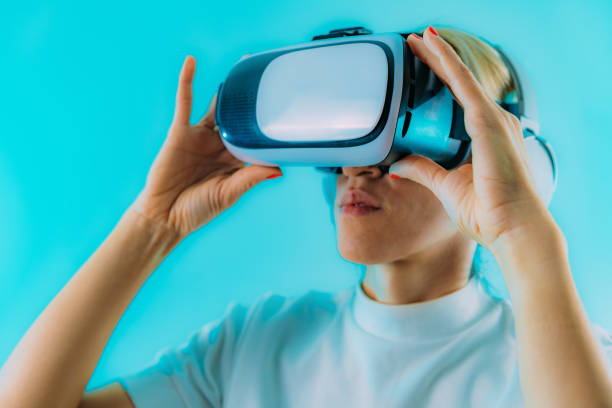 istock Woman with Virtual Reality headset exploring metaverse world. Blue copy space 1438104760