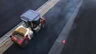 istock Road roller compacts the hot asphalt after paver in puffs of steam, drone view 1438105119