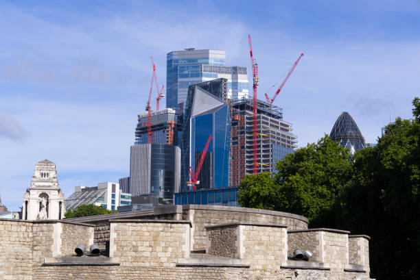 青い曇りの夏の日にシティ・オブ・ロンドンの前景にロンドン塔を持つ金融街の近代的なスカイライン。 - crane skyline uk tower of london ストックフォトと画像