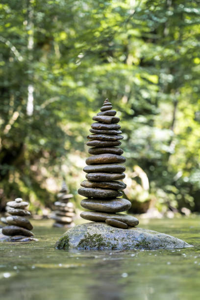 istock Vertical shot of many stone pyramids balanced on a river water 1438112408