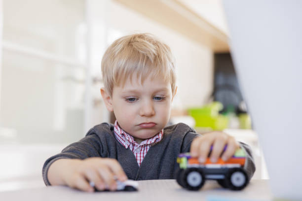 istock Blond toddler playing with toy car on the kitchen table 1438112594